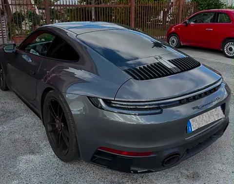 Porsche 911 Carrera 4 GTS grigia vista di tre quarti posteriore